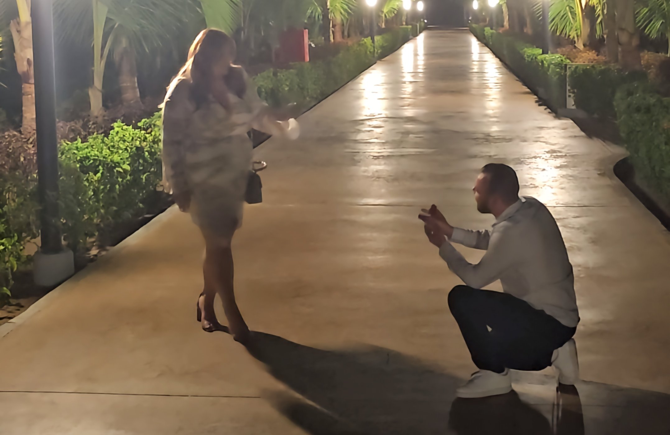 Tyler and Rhys smiling together in a romantic moment, surrounded by tropical Cape Verde scenery with ocean and golden sunset in the background, capturing the warmth and joy of their love story